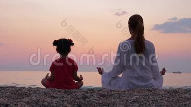 母亲和她的小女儿一边欣赏日落，一边在海边或海边沉思。